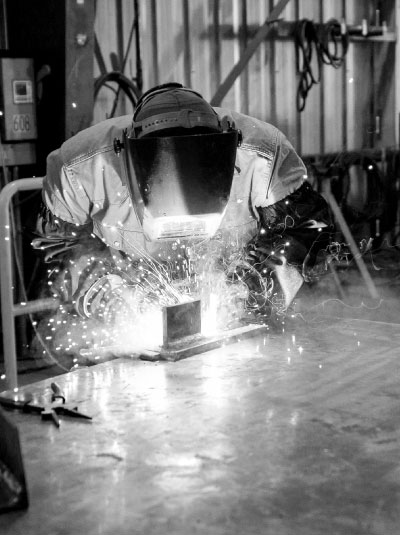 black and white of Con-Vey fabricator welding sparks flying