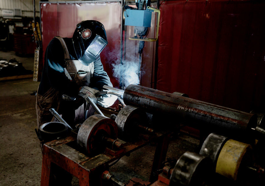 welder fabricator making welding conveyor roll at Con-Vey fabrication shop in Roseburg Oregon