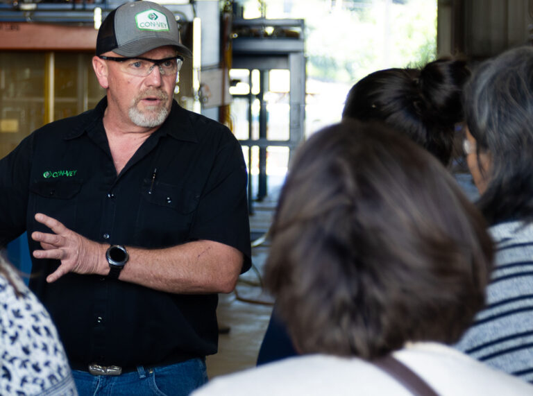 A Con-Vey leader speaks with women from the community in the Con-Vey shop